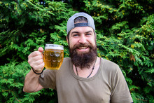 Beer Is Great Summer Drink. Bearded Man Holding Beer Mug On Summer Nature. Brutal Hipster Drinking Refreshing Beer On Summer Day. Happy Drinker Enjoying Summer Time