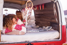 Vanlife Lifestyle And Travel Concept With Beautiful Curly Caucasian Woman Sleeping Inside A Red Old Vintage Van  Young People Traveling With Camper - Restored Vehicle And Alternative Life