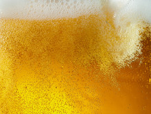 Close Up View Of Floating Bubbles In Light Golden Colored Beer Background. Texture Of Cooling Summer's Filtered Drink With Foam And Macro Fizz On The Glass Wall. Fizzing Or Floating Up To Top Of
