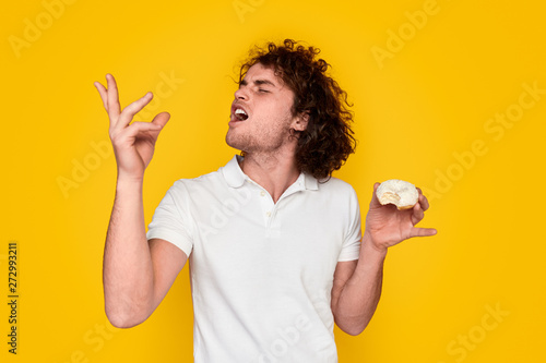 Fotomural Young man tasting yummy doughnut