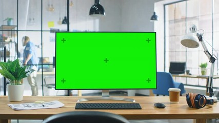 Wall Mural - wide green mock-up screen desktop computer standing on the desk in the modern creative office. in th