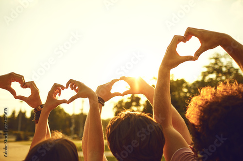 Cuadros en Lienzo Hands of group friends in the shape of a heart against the sunset