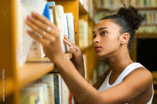 Cuadros en Lienzo Black african american young girl student studying at the school university libr