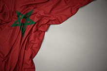 Waving National Flag Of Morocco On A Gray Background.