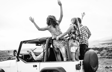 Wall Mural - Group of friends driving off road convertible car during roadtrip - Happy travel people having fun in vacation - Friendship, transportation and youth lifestyle holidays concept