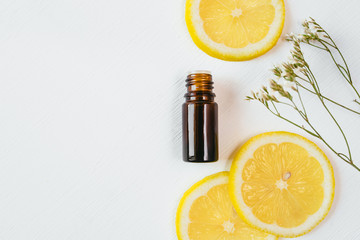 Bottle of lemon essential oil on white background for beauty, skin care, wellness and medicinal purposes. Flat lay.