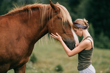 young beautiful girl hugging horse at nature. horse lover.