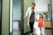 © Natalie Faye - Woman doctor walks young patient to examination room