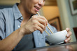 © Natalie Faye - Close up of man's hand holding chopsticks in bowl