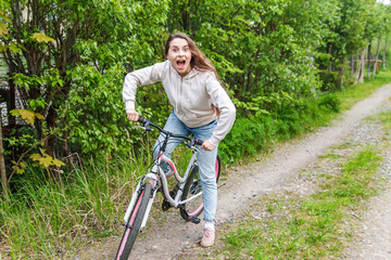 Young woman riding bicycle in summer city park outdoors. Active people. Hipster girl relax and rider bike. Cycling to work at summer day. Bicycle and ecology lifestyle concept