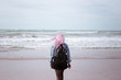 © Lalandrew - young girl with pink hair with black backpack admiring the sea