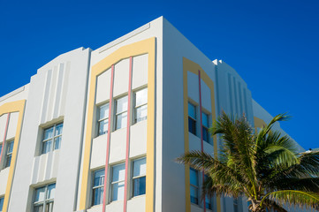 Detail close-up of typical colorful Art Deco architecture with tropical palm tree on Ocean Drive in South Beach, Miami, Florida