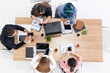 © InfiniteFlow - Top view of businessman executive in group meeting with other businessmen and businesswomen in modern office with laptop computer, coffee and document on table. People corporate business team concept.