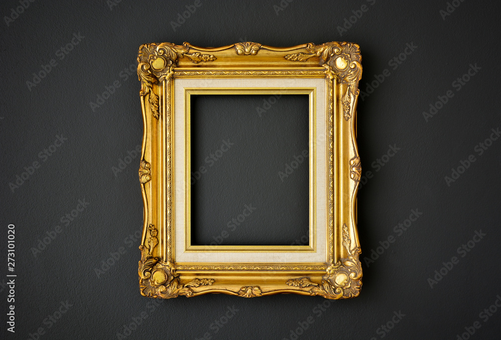 gold vintage picture frame on black color wall background, copy