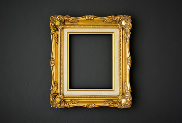 gold vintage picture frame on black color wall background, copy space, funeral and mourning concept