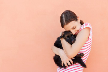 Wall Mural - Beautiful girl hugging tight her cute small puppy