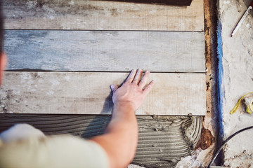 Wall Mural - Leveling ceramic tiles on a floor. Shallow depth of field.