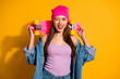 Close up photo beautiful she her lady coquette wink eye nice look hands arms skate board dangerous sport glossy pomade wear casual jeans denim jacket shoes pink hat isolated yellow vivid background