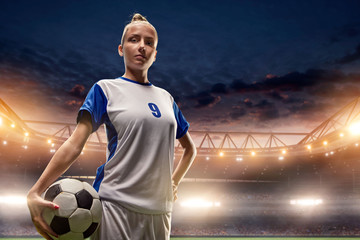 Female Soccer player with ball on a professional soccer stadium