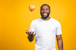 © denis_vermenko - Healthy african american man holding an apple isolated against yellow background.