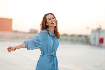 Wall Mural - portrait of a girl on a rooftop enjoying sunset