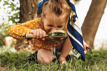 Image Of Cute Kid With Magnifying Glass Exploring The Nature Outdoors. Adorable Little Girl Playing In The Forest With Magnifying Glass. Curious Child Looking Through Magnifier On A Sunny Day In Park