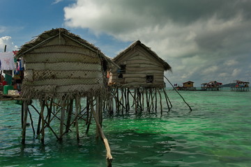 Wall Mural - East Malaysia. A village of sea Gypsies in the middle of the ocean engaged in fishing.