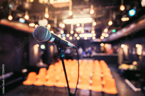 Photographie Empty event hall: Close up of microphone stand, empty seats in the blurry backgr