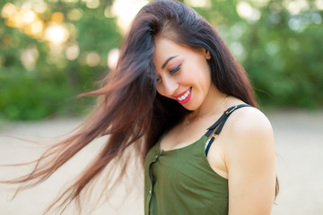 Brunette woman with high volume beautiful hair at nature