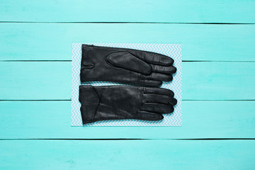 Leather gloves on blue wooden background. Top view