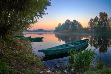 Wall Mural - old fishing boat on the lake at the sunrise