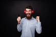 © Vulp - Photo of cheerful bearded young man, celebrating with arms up, while using a mobile phone and headphoneas