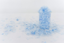 Bottle Flake,PET Bottle Flake,Plastic Bottle Crushed,Small Pieces Of Cut Blue Plastic Bottles In Beaker Glass.Chemical Concept