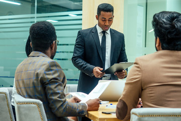 Wall Mural - well-dressed business afro american men making a report to subordinate employees in a modern office