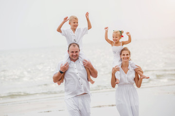 Wall Mural - Happy young family on the sunset at the beach.