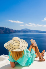 Wall Mural - Luxury travel vacation woman looking at view on Santorini island