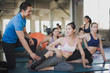 © linghaa - Group of young woman are stretching the body before exercise under coaching or trainer advise them at the gym. Woman workout and training yoga at fitness room concept.