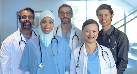 Happy medical team of doctors looking at camera in the hospital