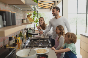 Family preparing food in kitchen at home