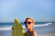 Leinwandbild Motiv Woman standing with surfboard at beach in the sunshine