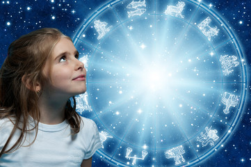 a girl looking at horoscope with zodiac signs like astrology and child, children, kids concept