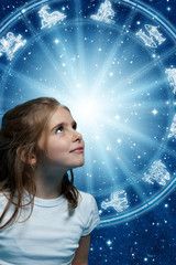 a girl looking at horoscope with zodiac signs like astrology and child, children, kids concept