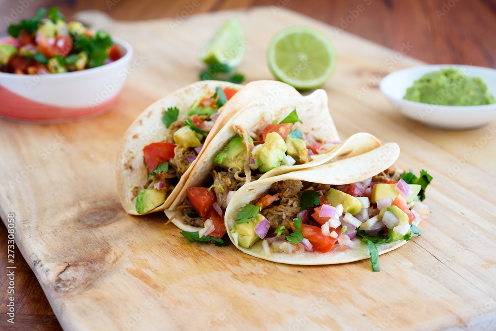 Pulled pork tacos with salsa, guacamole and lime in background, with copy space - obrazy, fototapety, plakaty 