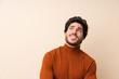 © luismolinero - Handsome over isolated wall looking up while smiling