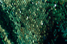 Fabric With Emerald Sequins. The Texture Of The Shiny Material. Decorative Fabric Trimmed With Green Sequins.