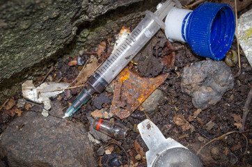 close-up of syringe and other debris discarded by drug users on patch of waste ground, wolverhampton