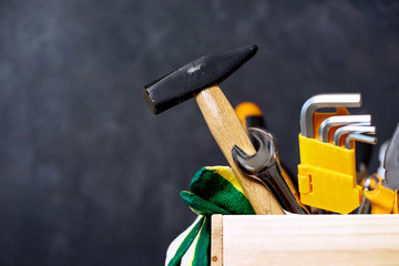 construction tools in wooden box in black background