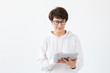 © satura_ - Cute middle-aged woman in casual clothes is looking online stores using a tablet on a white background. Concept of wireless internet and online shopping. Copyspace.