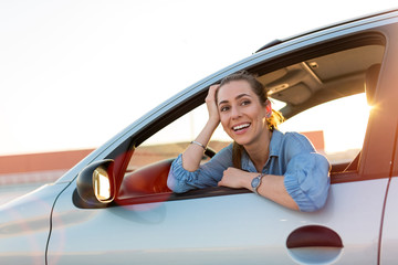 Wall Mural - Happy woman driving a car and smiling