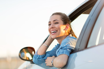 Wall Mural - happy woman driving a car and smiling